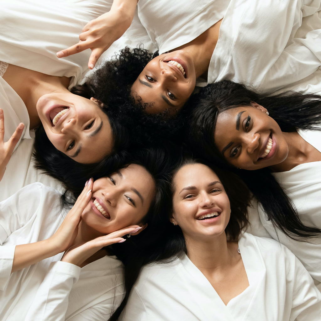 A group of five women laying on a bed